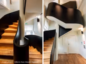 2 vues d'un grand escalier à la rampe pleine et noire avec marche en bois.